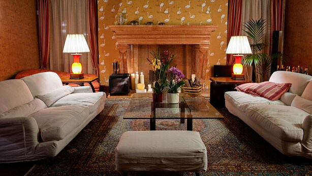 A living room with two sofas, a coffee table, a fireplace, and lamps. - Residenza Borsari (Verona)