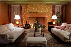 A living room with two sofas, a coffee table, a fireplace, and lamps.