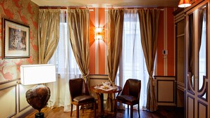 A room with a round table, two chairs, a globe, and a wall-mounted lamp. - Residenza Borsari (Verona)