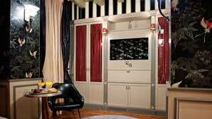 A room with a dining table set with breakfast, a black chair, and a decorative wall with a floral pattern. - Residenza Borsari (Verona)