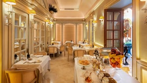 A formal dining room with tables set for service, elegant chandeliers, and a view of the outdoors. - Hotel Boutique Casa del Poeta Sevilla (Seville)