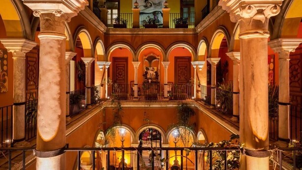 A grand atrium with multiple arches and columns, a central staircase, and a balcony with railings. - Hotel Boutique Casa del Poeta Sevilla (Seville)