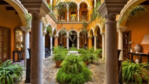 A courtyard with columns, potted plants, and a central fountain. - Hotel Boutique Casa del Poeta Sevilla (Seville)