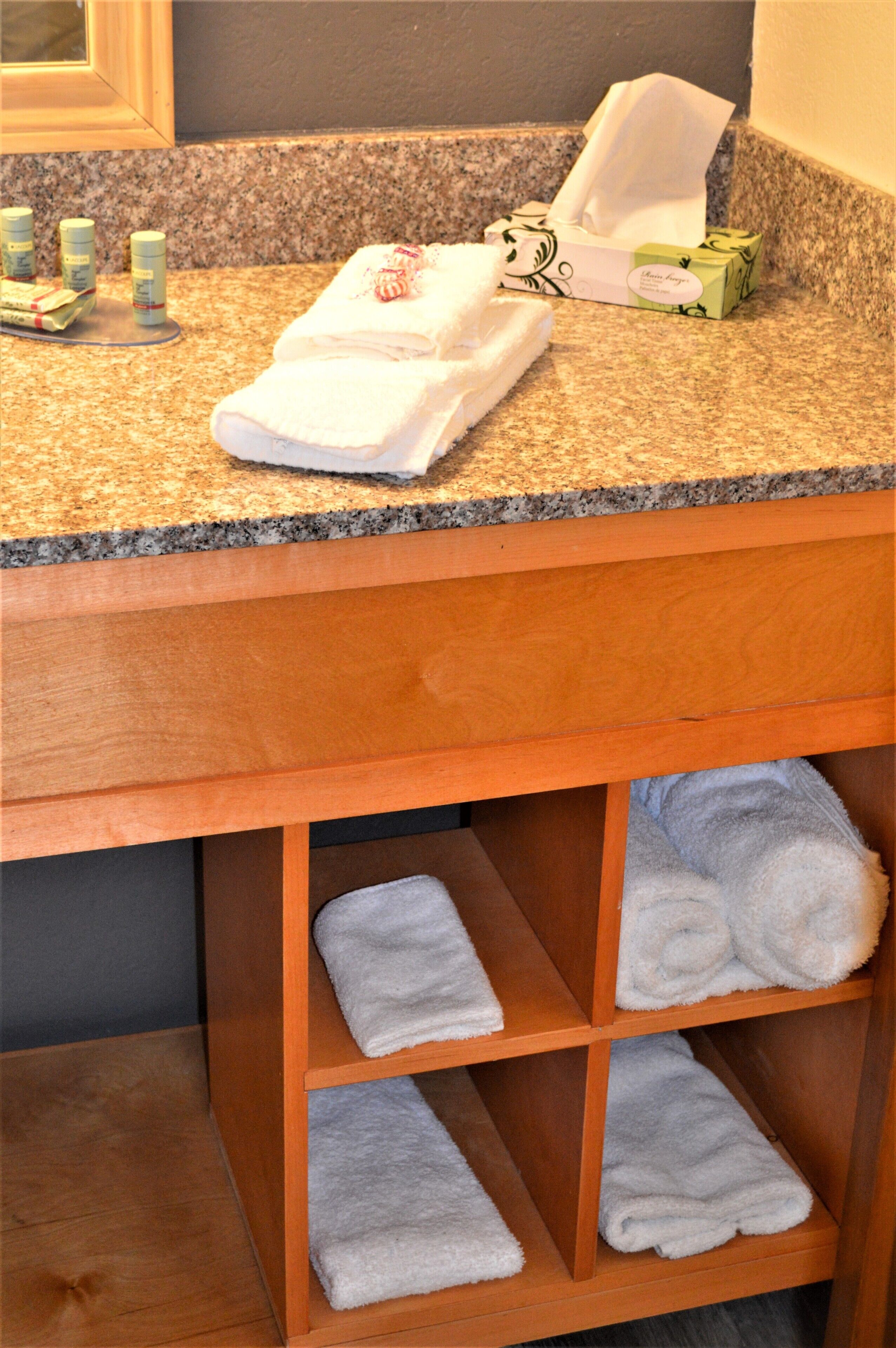 Una encimera de baño con una toalla, un neceser y una caja de pañuelos.