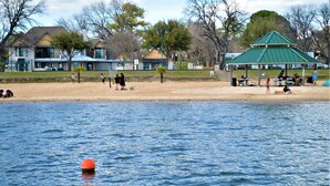 A lakeside park with a gazebo, picnic tables, and a sandy beach. - Lake View Inn (Granbury)