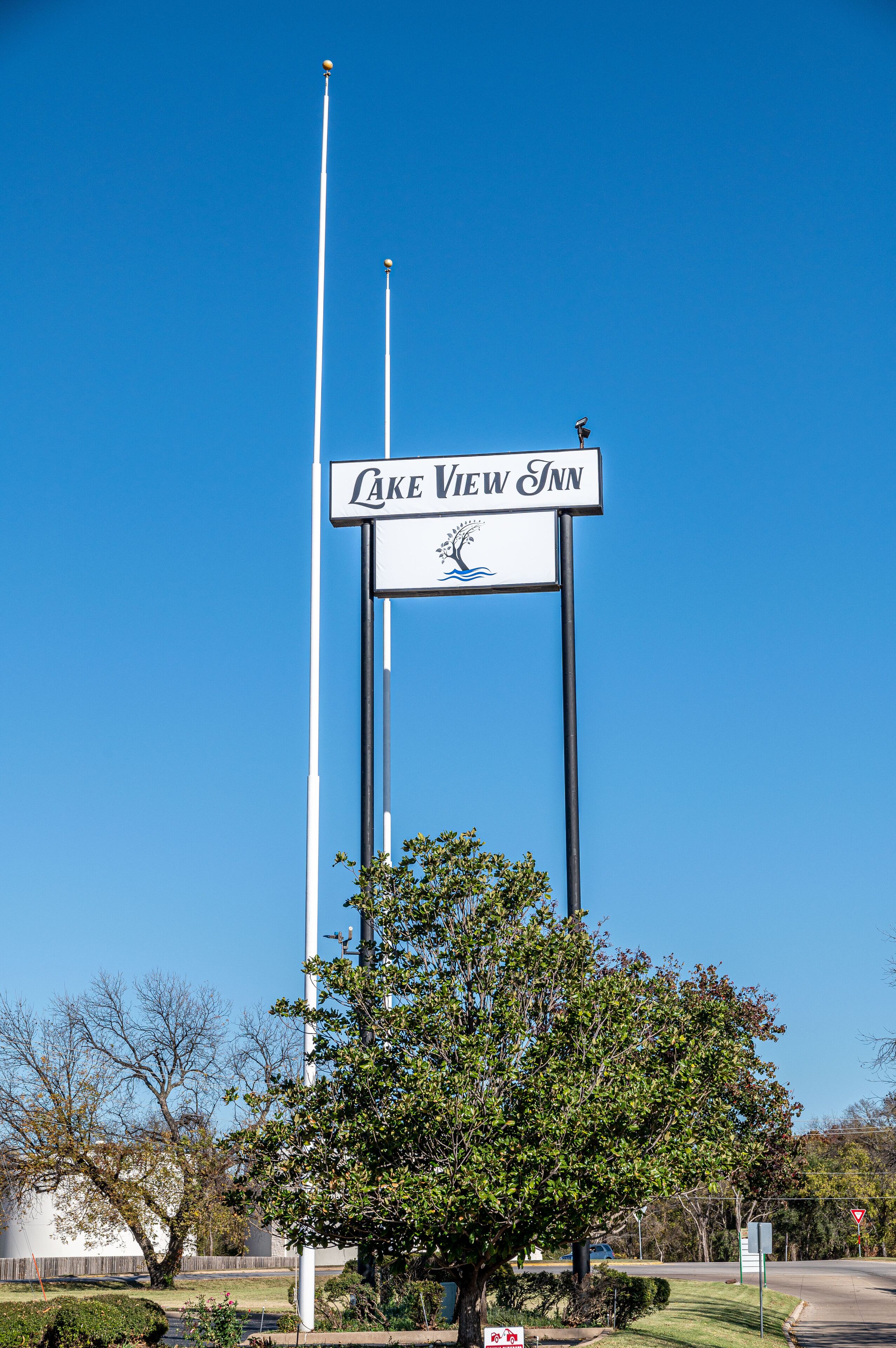 A sign for Lake View Inn with a clear sky and a tree in the foreground.