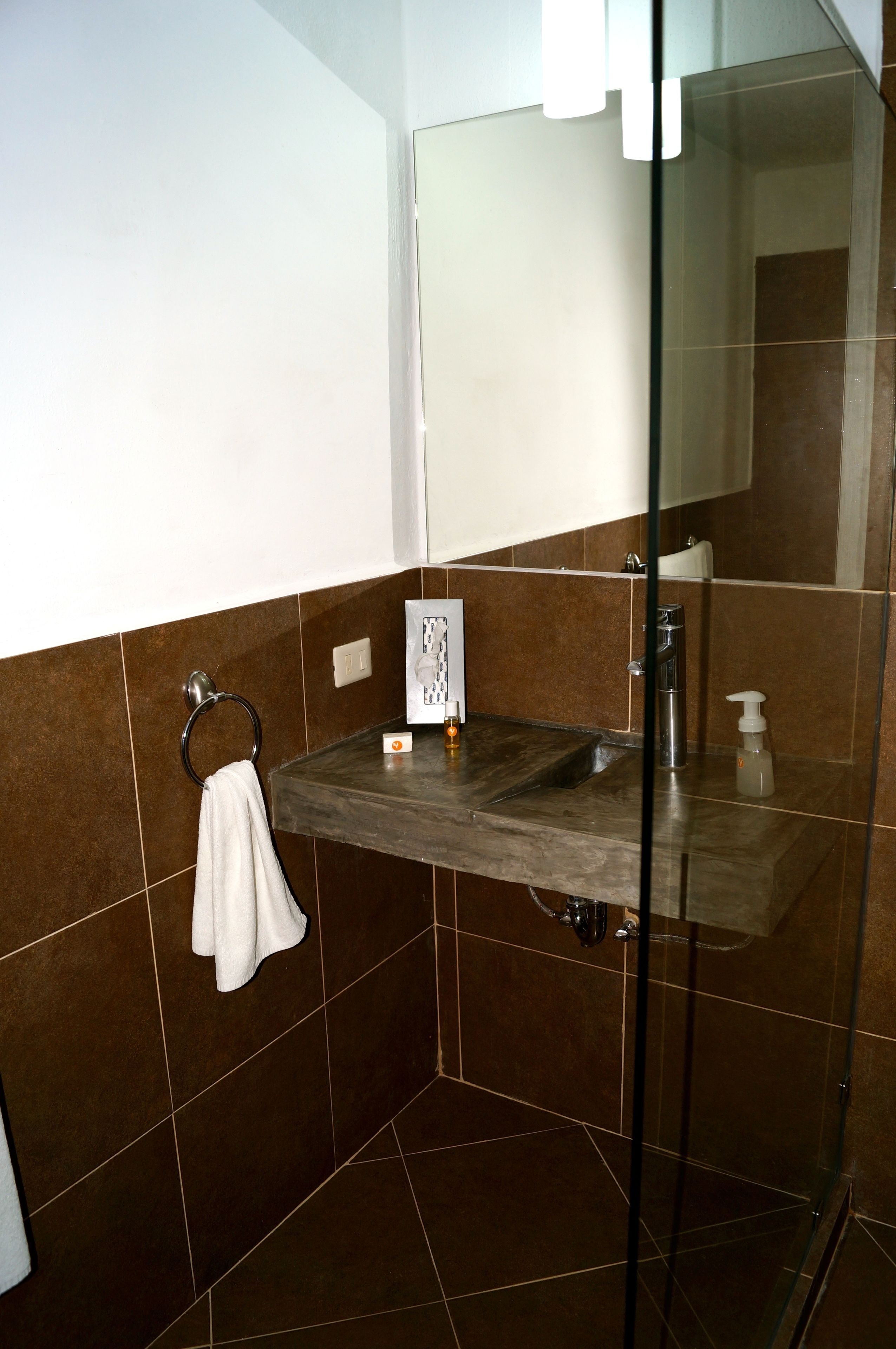 Ein Badezimmer mit Duschkabine aus Glas, Marmorwaschbecken und Handtuchhalter.