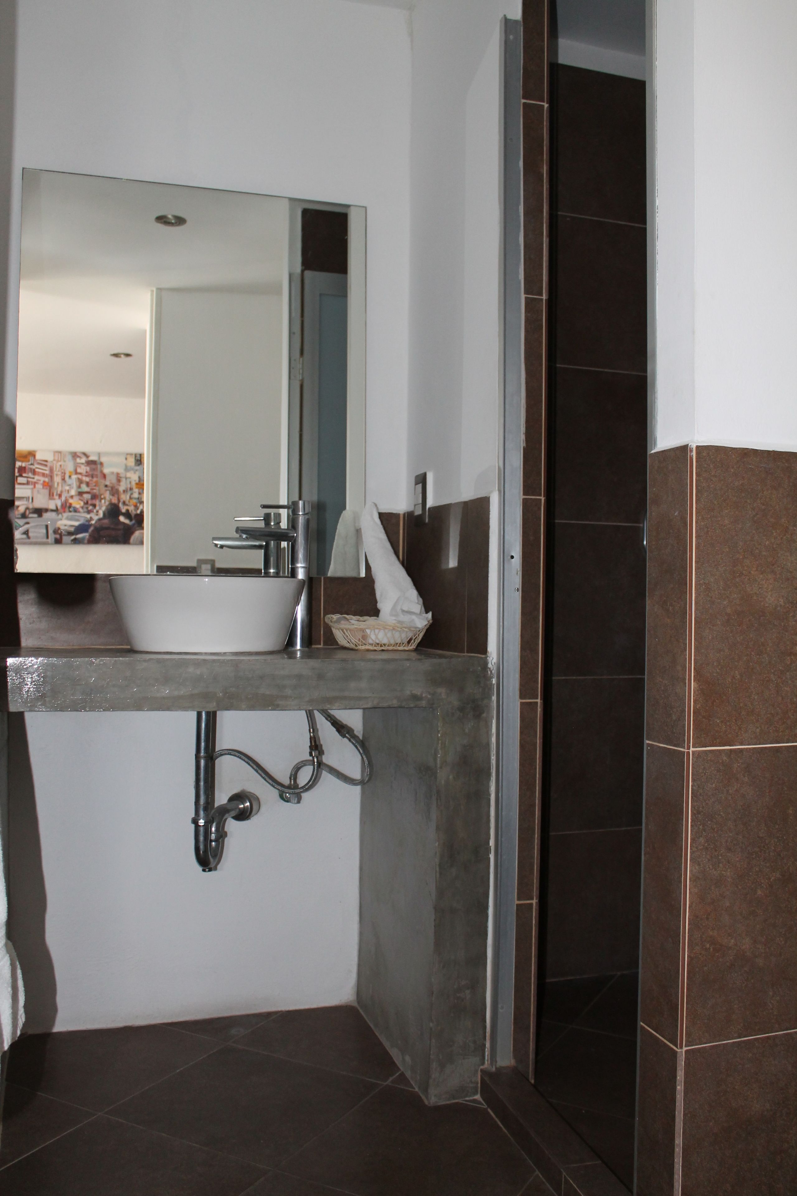 A bathroom with a white sink, a mirror, and a shower area.