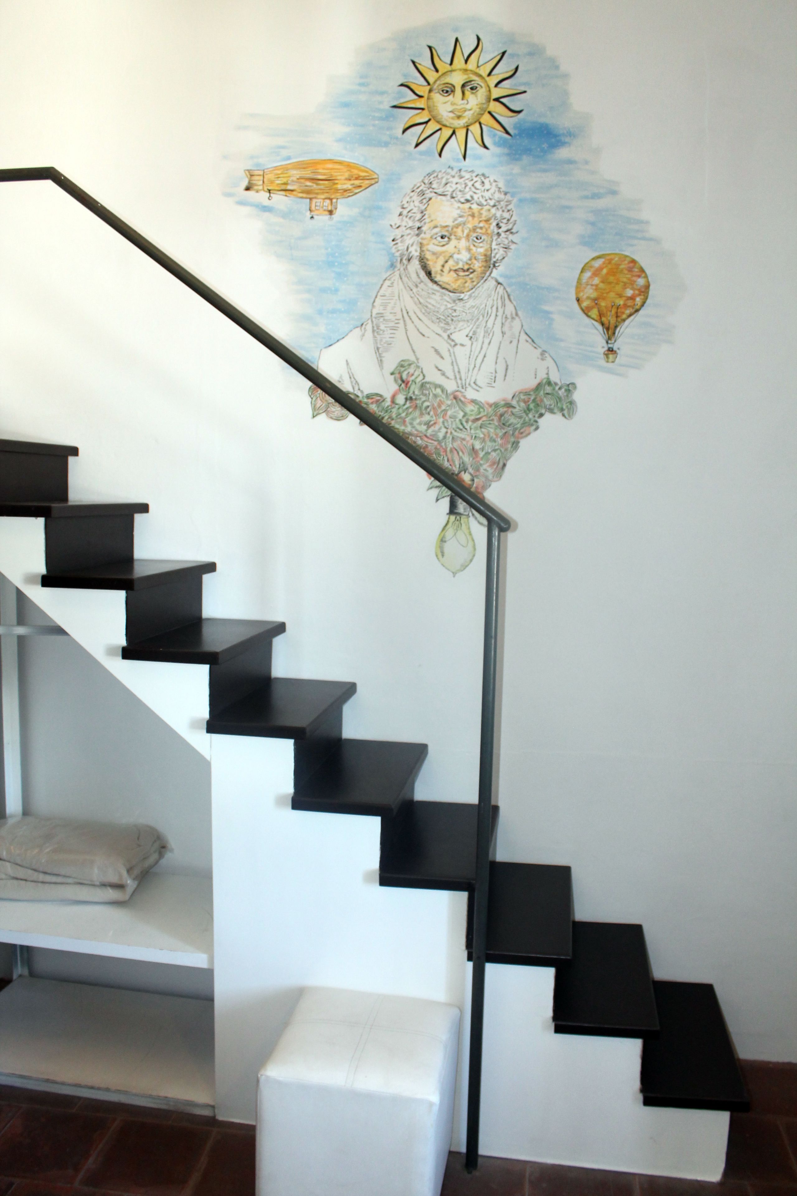 A staircase with black steps and a white wall.