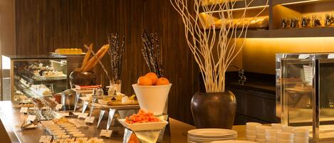 Una mesa de buffet con diversos alimentos y utensilios.