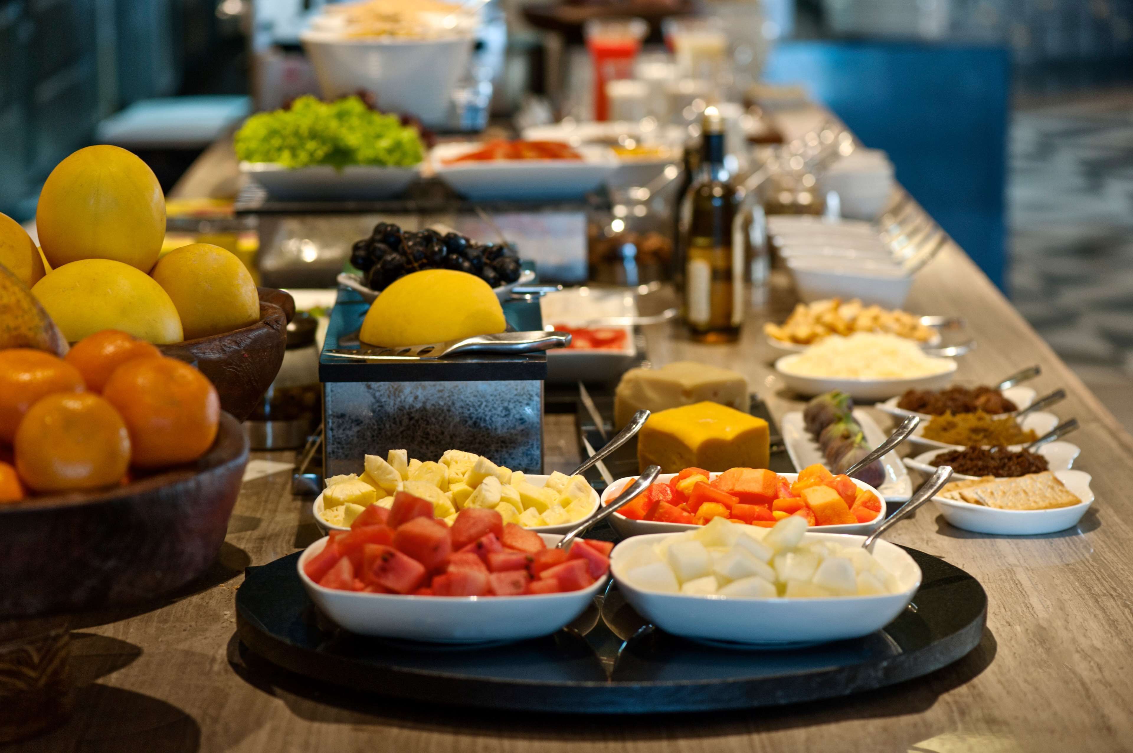 A buffet with various food items including fruits, cheeses, and vegetables.