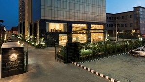A modern Hyatt Regency hotel with a glass facade, a well-lit entrance, and a gated driveway. - Hyatt Regency Ludhiana (Ludhiana)