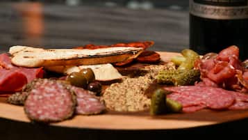 A charcuterie board with various meats, cheeses, and olives.