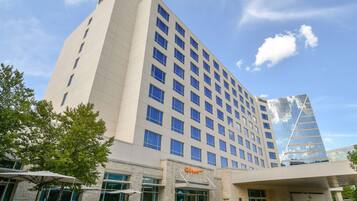 A multi-story hotel with a modern design, featuring a large glass facade and a prominent Hilton logo.