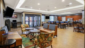 A spacious lobby with seating areas, a reception desk, and a large TV screen. - La Quinta Inn & Suites by Wyndham Glendive (Glendive)