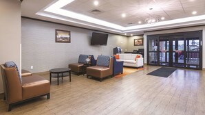 A lobby with seating, a television, and a reception area. - La Quinta Inn & Suites by Wyndham Glendive (Glendive)