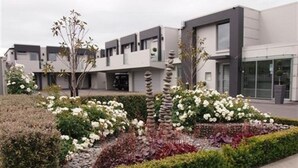 A modern building with a flat roof, rectangular windows, and a symmetrical facade. - Bellano Motel Suites (Christchurch)