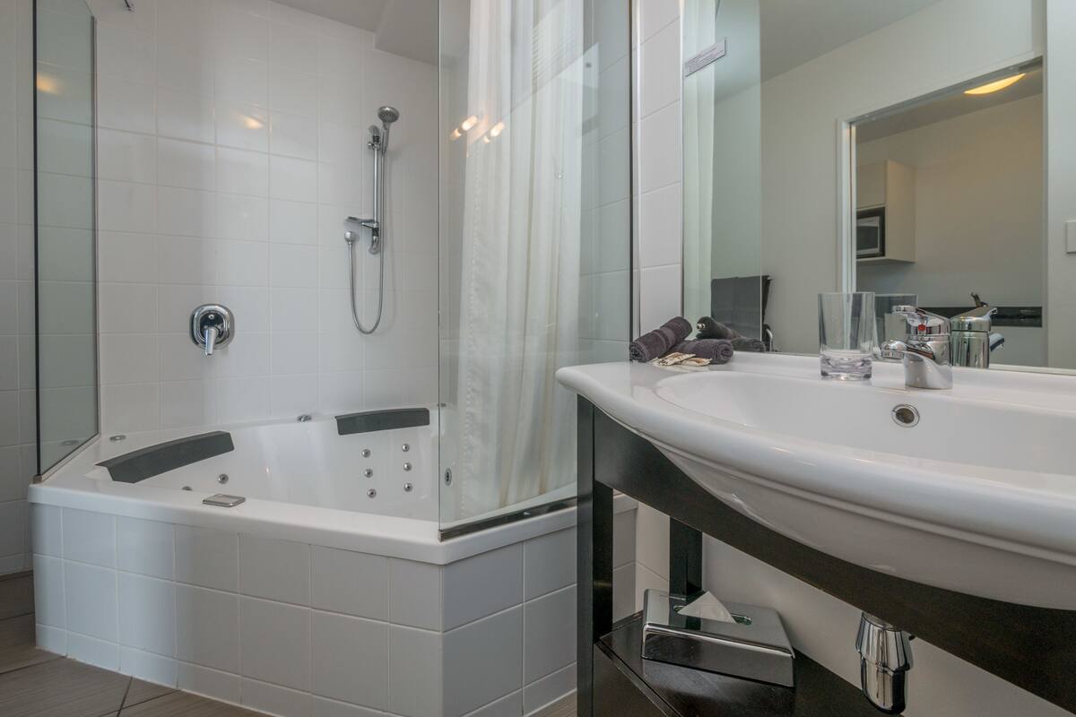 A modern bathroom with a bathtub, a sink, and a shower.