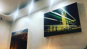 Two large wall-mounted photographs of famous landmarks, a potted plant, and two wall-mounted lights. - City Life Rome (Rome)