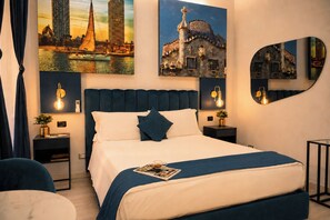 Una habitación de hotel moderna con una cama grande, dos mesitas de noche, una lámpara de noche, una silla y un espejo redondo.