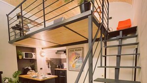 A modern kitchen with a wooden island, a staircase, and a dining area. - City Life Rome (Rome)
