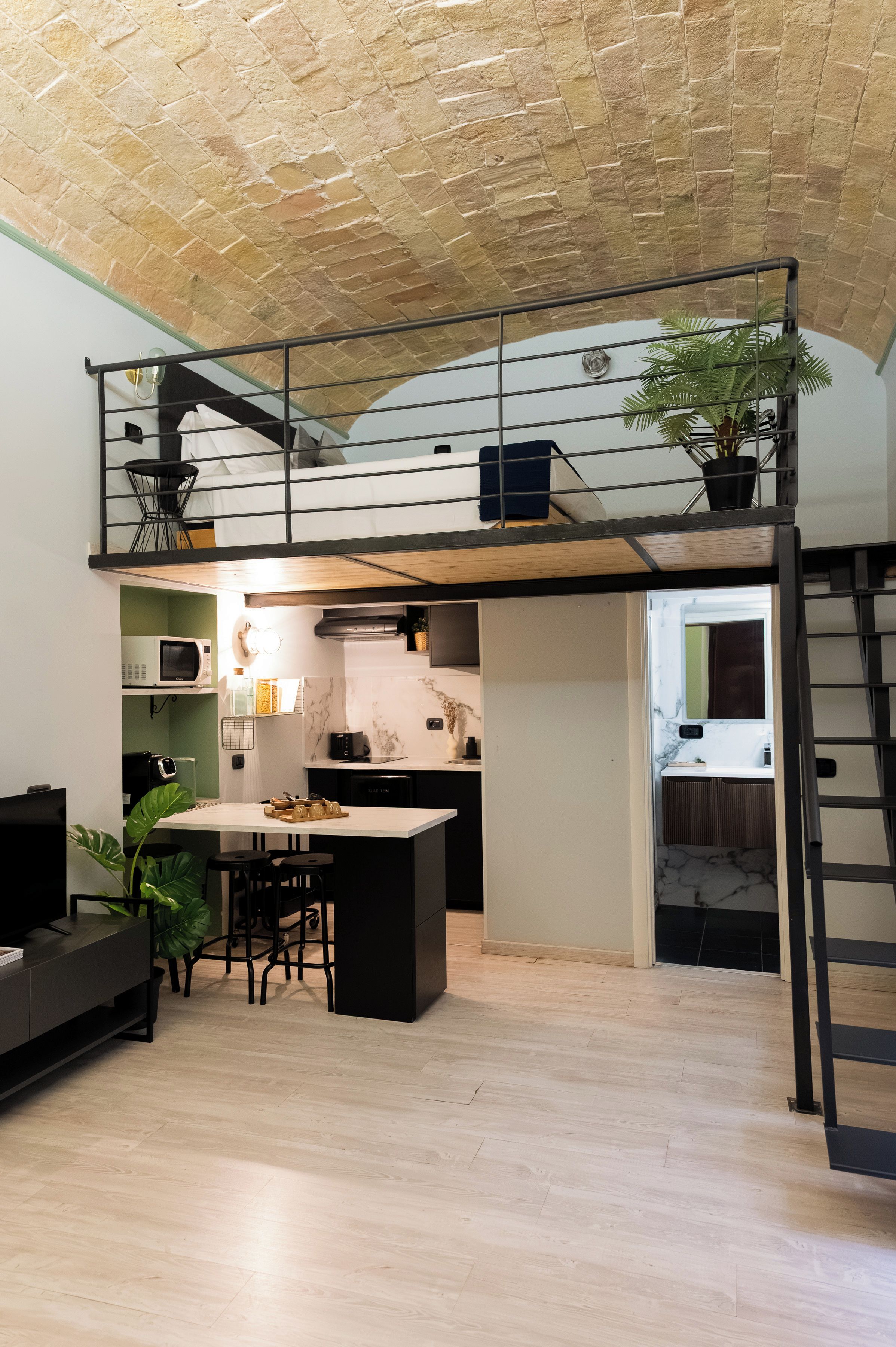 Espacio habitable compacto con dormitorio entrepiso, kitchenette y comedor.