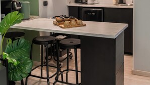 Eine moderne Küche mit einer zentralen Kochinsel, Barhocker, einer Mikrowelle und einem eingebauten Backofen.