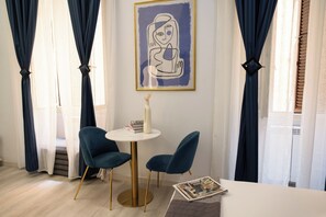 A room with a round table, two chairs, a framed artwork, and a vase. - City Life Rome (Rome)