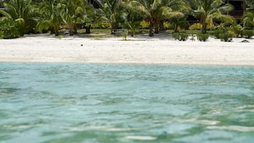 On the beach, white sand, sun loungers, beach towels