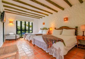 Una habitación con dos camas, una mesa de madera y un banco.