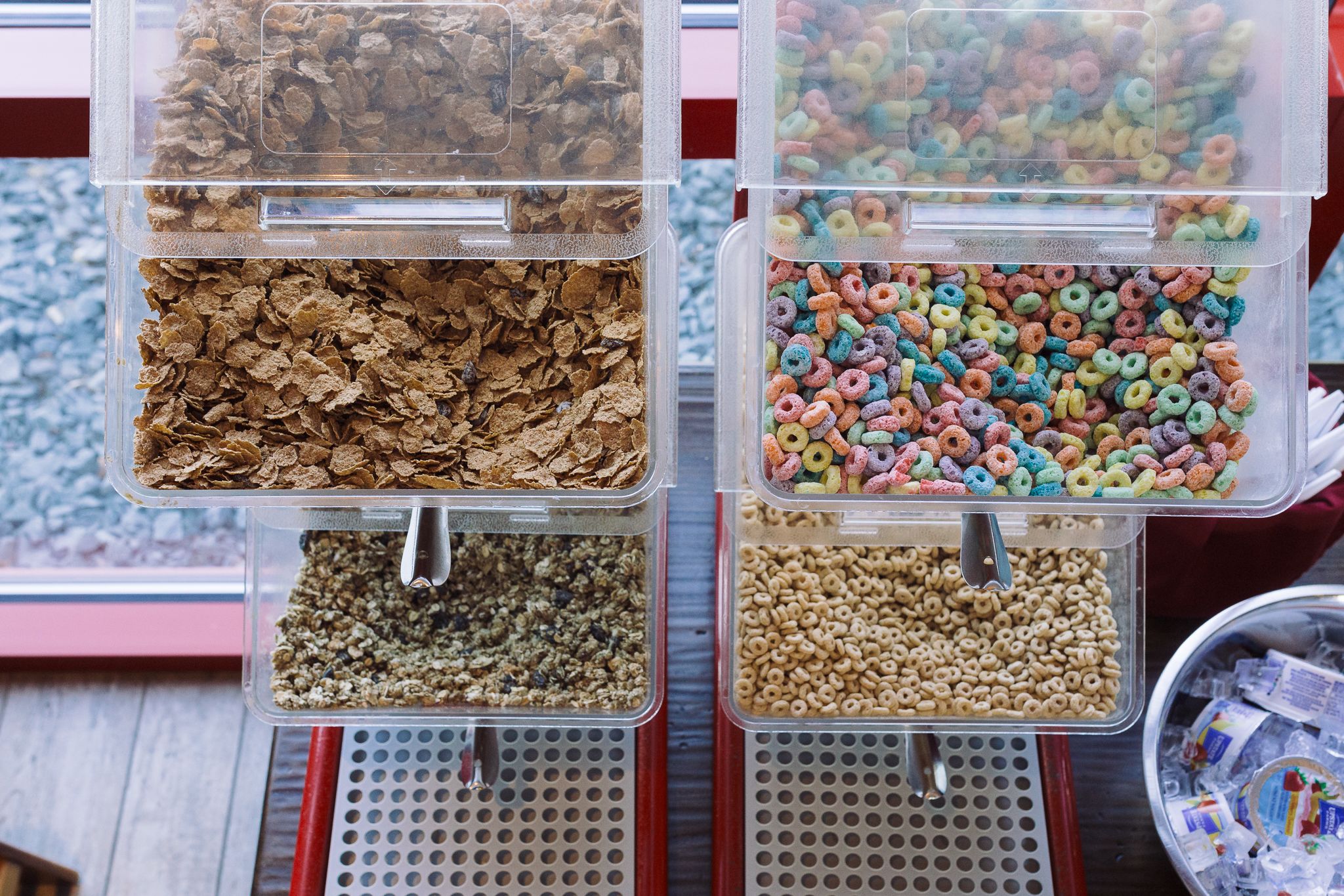 Four cereal dispensers with different types of cereals.