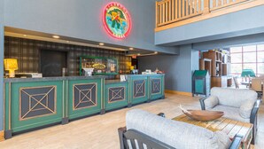 Eine geräumige Lobby mit Empfangsschalter, Sitzgelegenheiten und Blick ins Freie.