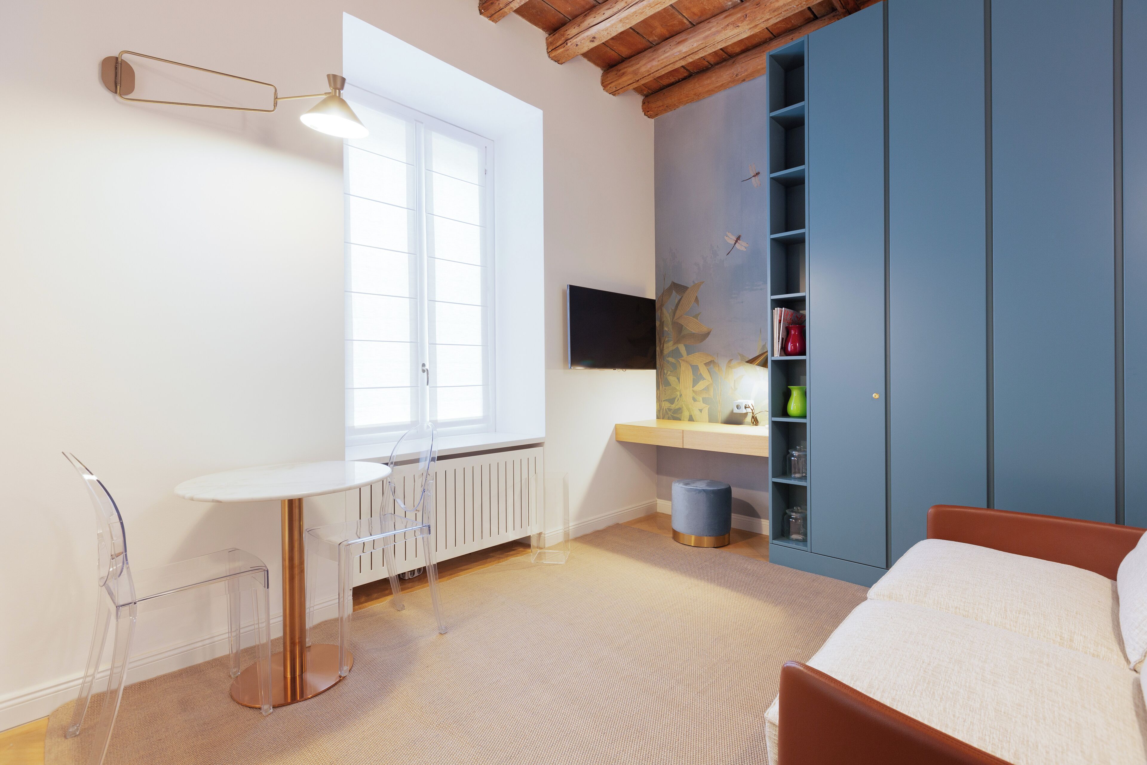 A modern bedroom with a bed, a desk, and a wardrobe.