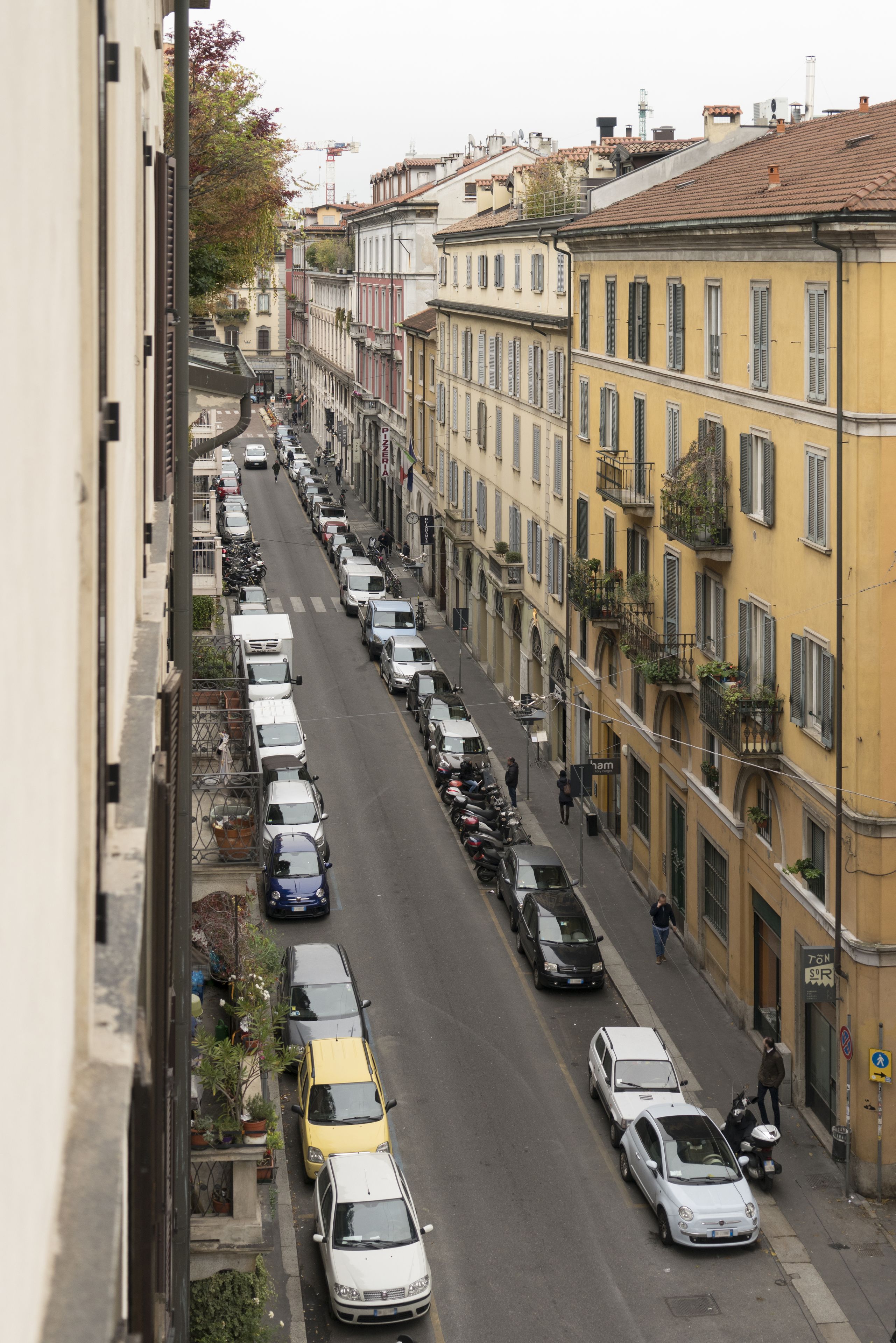 Vista de la calle con coches aparcados y edificios.