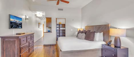 Un dormitorio con cama, mesita de noche, cómoda y ventilador de techo.