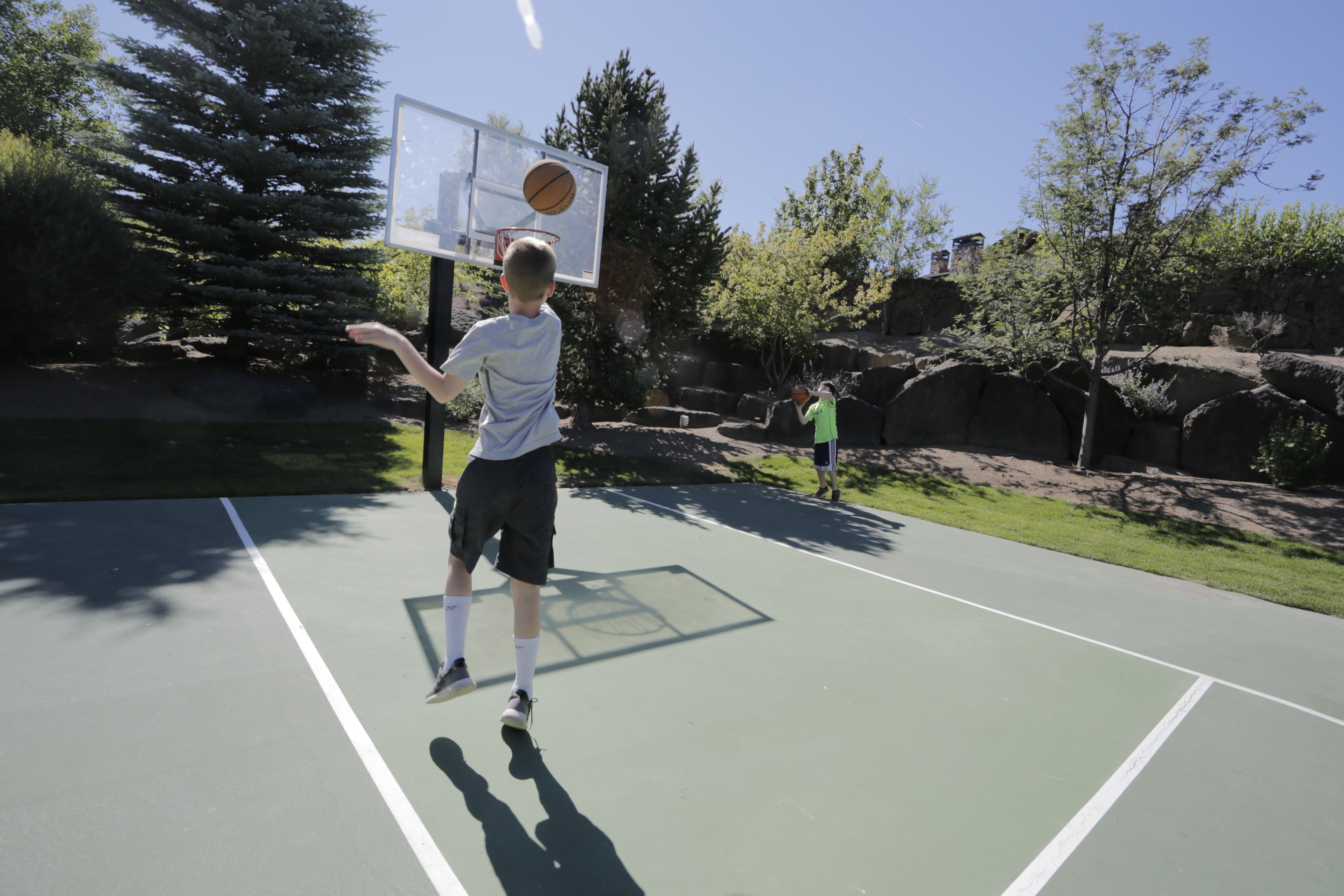 An outdoor basketball court with a hoop and a net.