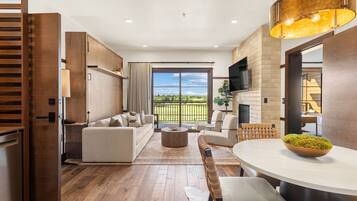 A modern living room with a sofa, chairs, a coffee table, and a dining table.