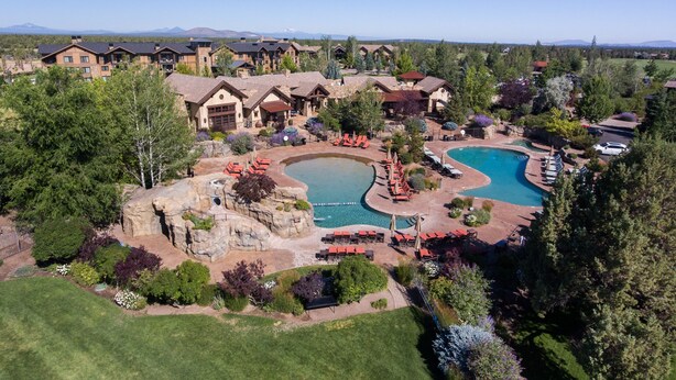 A resort with multiple pools, outdoor seating, and a mountainous backdrop. - Juniper Preserve (Bend)