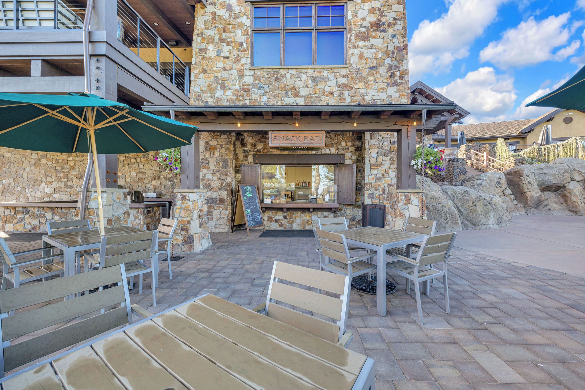 An outdoor seating area with stone walls and a snack bar.