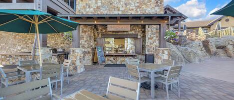 An outdoor seating area with stone walls and a snack bar.