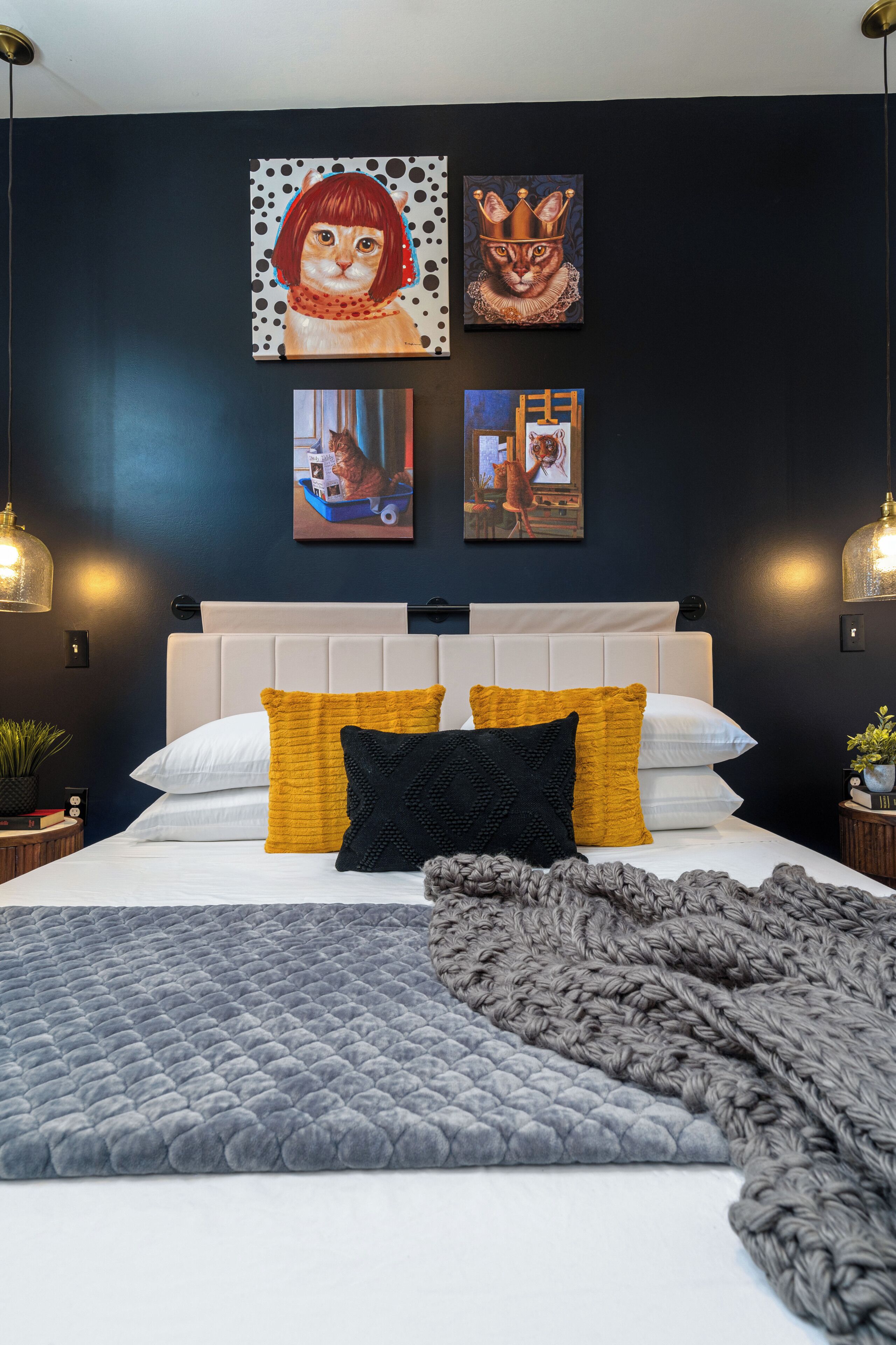 Un dormitorio con cama, almohadas, manta y decoración en la pared.