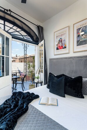 A hotel room with a bed, a window, a balcony, and a door. - Saint Philip French Quarter (New Orleans)