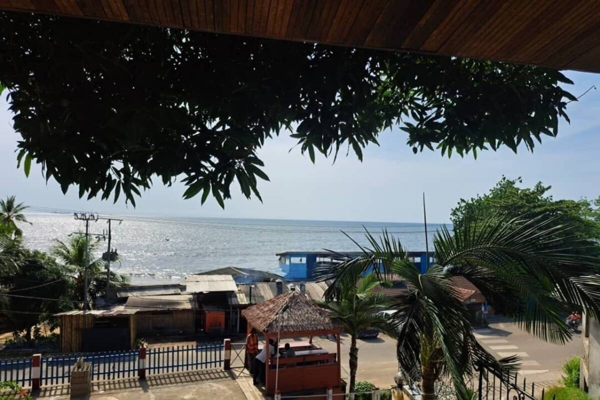 Une vue sur la côte, avec une plage, une petite cabane et un bâtiment bleu.