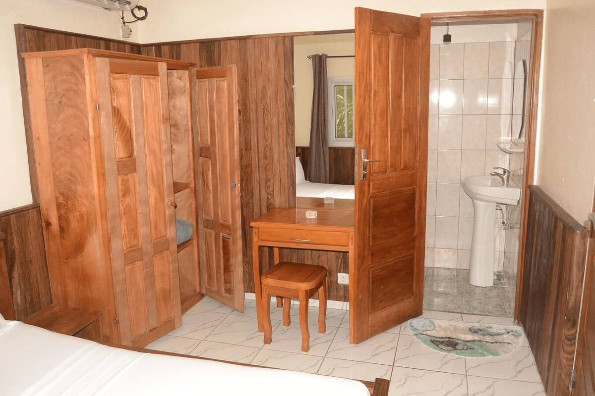 Une salle de bain avec un meuble-lavabo en bois, un évier et un espace douche.