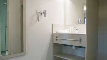 Un baño moderno con un espejo grande, un lavabo y una cabina de ducha.