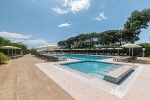 A swimming pool with lounge chairs and umbrellas, surrounded by trees and a clear sky. - Hotel & Resort Gallia (Jesolo)