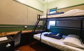 Un dormitorio con literas, un escritorio y una silla.