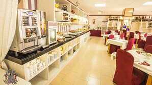 A buffet-style restaurant with a self-service coffee machine, a variety of food items, and a wine selection. - HOTEL VICTORIA (Calafell)