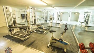 A gym with various exercise equipment, including treadmills, weight machines, and free weights.