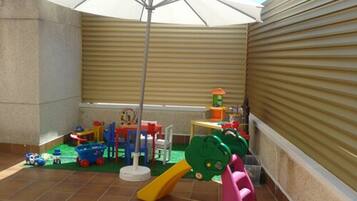 Children can play and explore in this safe, enclosed play area with a slide, climbing frame, and a variety of toys.